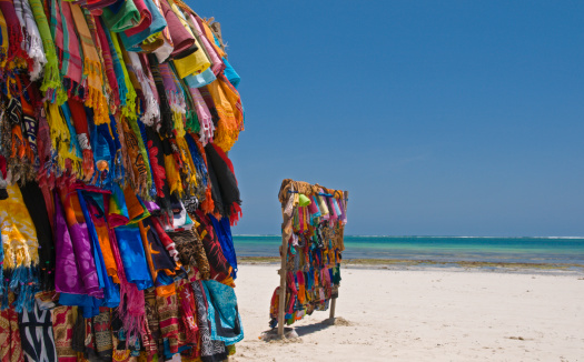 A man on the beach drying himself with a green towel