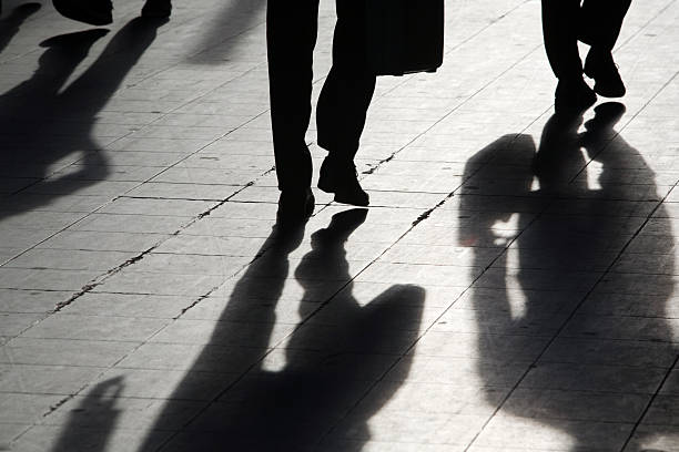 istock sun casting shadow over people walking on the street 117391865