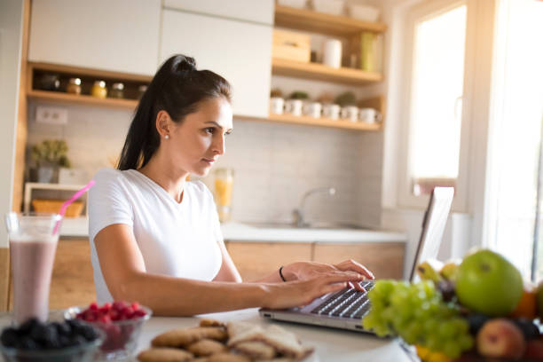 istock Young woman typing an e-mail on laptop at home 1173919280