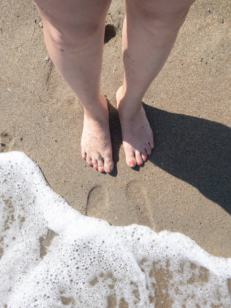 istock Human footprints - undefined human legs walking on the beach 1173920586