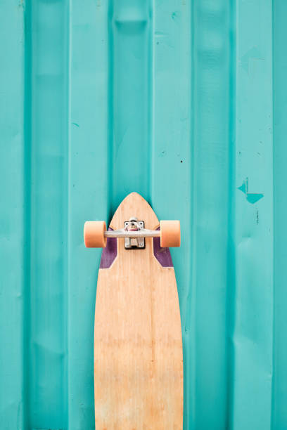 istock Longboard standing against cyan metal wall 1173922424