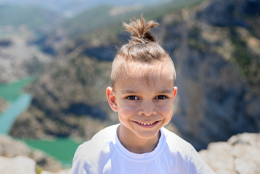kid on hill with river cliffs scenic view