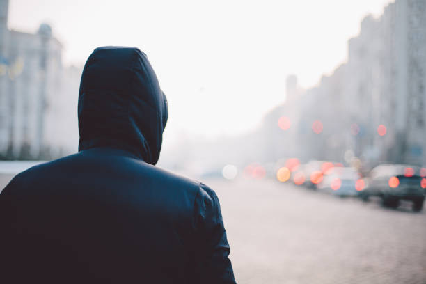 hombre solitario caminando en la calle de niebla - capucha fotografías e imágenes de stock