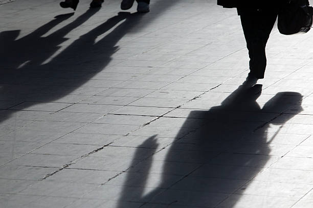 istock sun casting shadow over people walking on the street 117392691