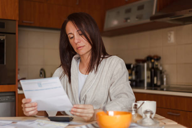 istock Woman going through bills, looking worried 1173927439