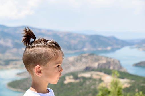 kid on hill with river cliffs scenic view
