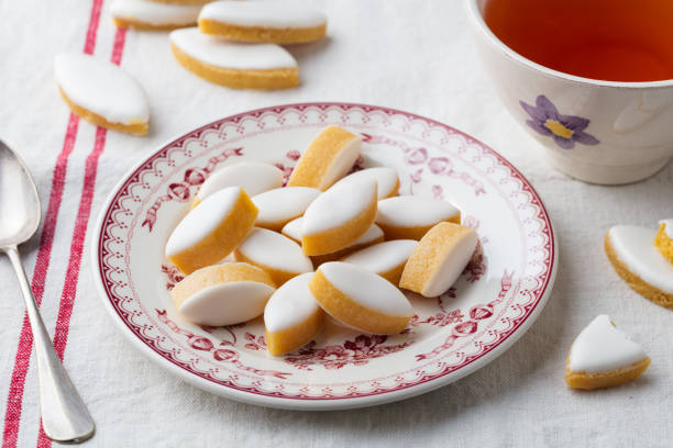 calissons na talerzu. tradycyjne francuskie słodycze prowansalskie z filiżanką herbaty. - glazed almond nut sugar zdjęcia i obrazy z banku zdjęć