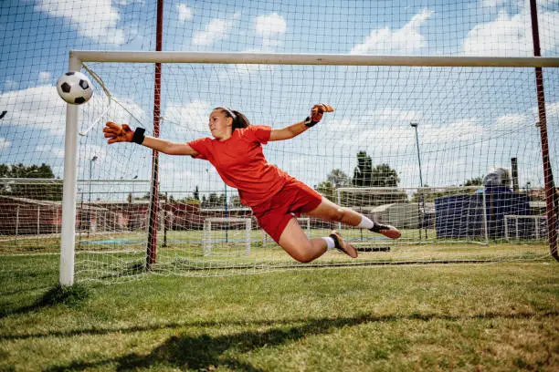 Photo of Soccer penalty kick with teen female goalkeeper