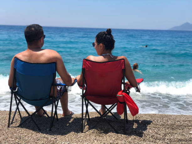istock Couple in loungers on beach 1173933006