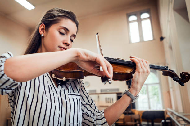 kobieta gra na skrzypcach w pobliżu okna w szkole muzycznej - practicing music violin women zdjęcia i obrazy z banku zdjęć