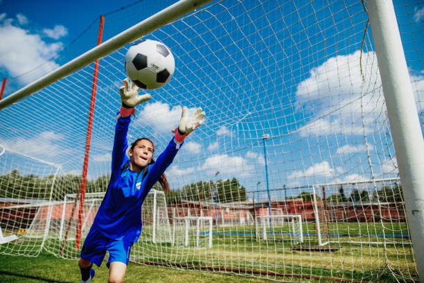 adolescente portero jugando al fútbol y defendiendo tiros penales - soccer teenager sport adolescence fotografías e imágenes de stock