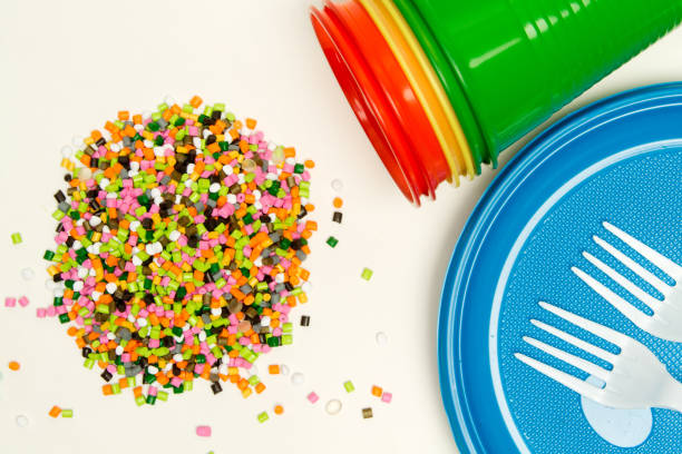 istock Plastic granules and disposable tableware made of polyethylene, polypropylene against the background of a polymeric material. BPA FREE 1173938864