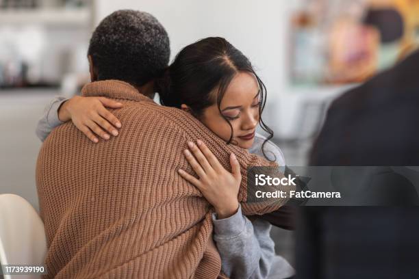 Supportive Women Hug While Attending A Group Therapy Session Stock Photo - Download Image Now