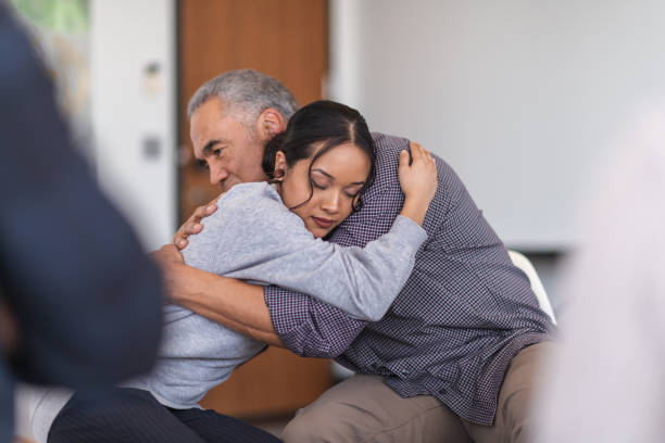 istock Father gives daughter a supportive hug in a group therapy session 1173939450