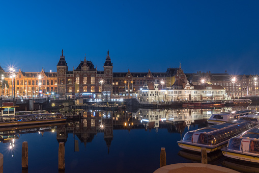 Amsterdam, Netherlands - June 6, 2019: Night view of Amsterdam canal and Centraal Station.