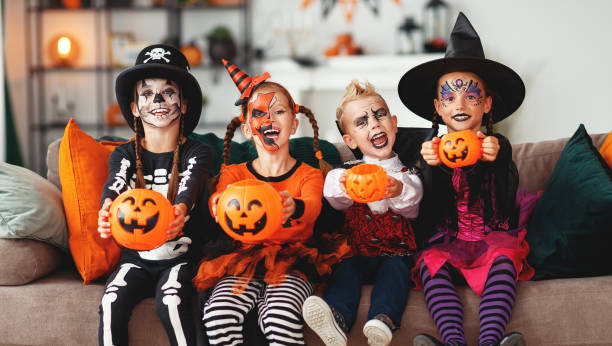 fröhliches halloween! eine gruppe von kindern in anzügen und mit kürbissen in haus - maskenkostüm stock-fotos und bilder