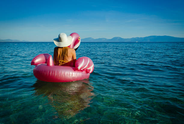 istock Woman on pink flamingo float 1173947020
