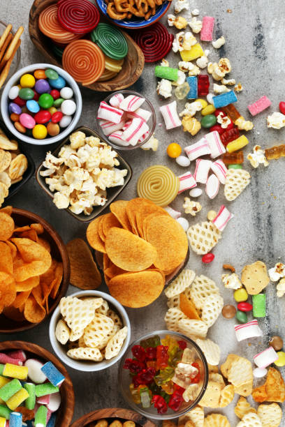 istock Salty snacks. Pretzels, chips, crackers and candy sweets on table 1173948263