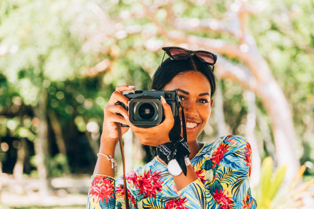 istock Young Black woman with retro digital camera 1173948432