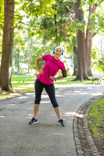istock Senior Woman is Doing Warm Up Exercise in Nature 1173948670