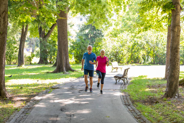 istock Active Senior Couple is Jogging Outdoors in Nature 1173949133