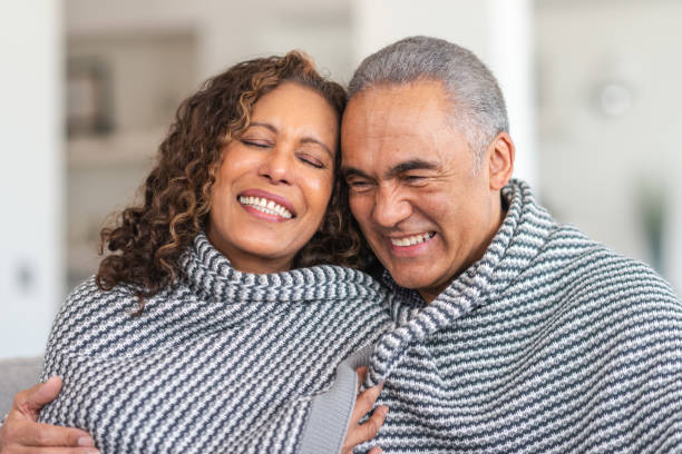 istock Happy senior couple snuggling in blanket 1173952998