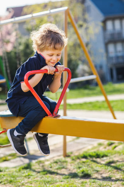 istock Young boy on teeter at playground 1173956687