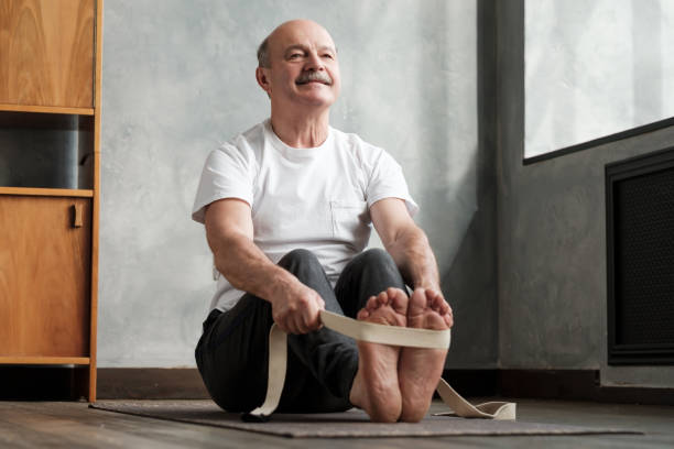 senior hispanic mann sitzt in paschimottanasana oder intensive dorsal stretch pose - senior adult sport yoga exercising stock-fotos und bilder