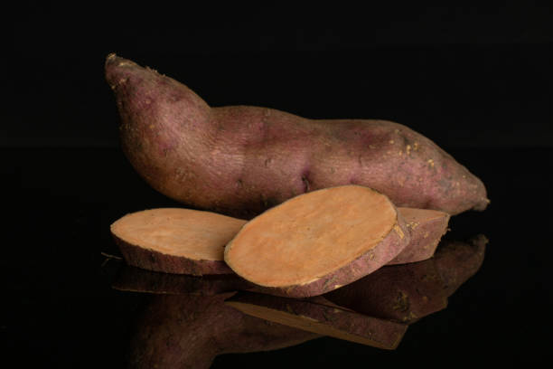 istock Fresh sweet potato isolated on black glass 1173960947