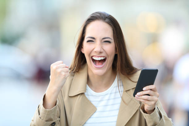 istock Excited woman holding phone looking at camera 1173961142