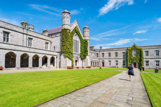 The Quadrangle Building National University of Ireland Galway Ireland People walk in The Quadrangle Building courtyard on the National University of Ireland campus in Galway Ireland on a sunny day. galway university stock pictures, royalty-free photos & images