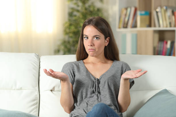 istock Doubtful woman looking at camera at home 1173961410