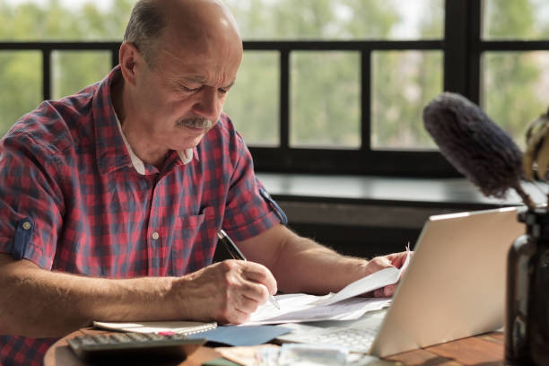 istock Senior hispanic man using calculator and calculate bills 1173963203