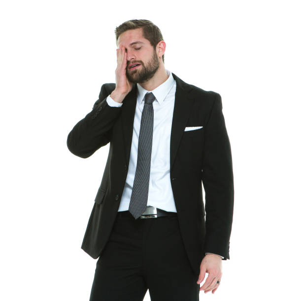 One man only / waist up / side view / profile view of 20-29 years old adult handsome people brown hair / short hair caucasian male / young men businessman / business person standing in front of white background wearing businesswear / button down shirt / shirt / necktie / a suit who is headache / emotional stress / dizzy / in pain / distraught / fever / illness / exhausted / feeling sad / depression - sadness / with anxiety / sulking with head in hands un hombre sólo / cintura para arriba / vista lateral / vista de perfil de 20-29 años de edad adulto guapo personas castaño pelo / pelo corto hombre caucásico / hombres jóvenes hombre de negocios / persona de negocios de pie frente a fondo blanco usand