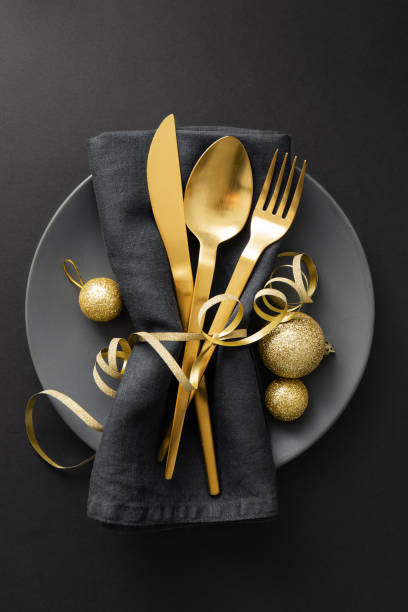 posate d'oro servite sul piatto per la cena di natale - table knife silverware black fork foto e immagini stock