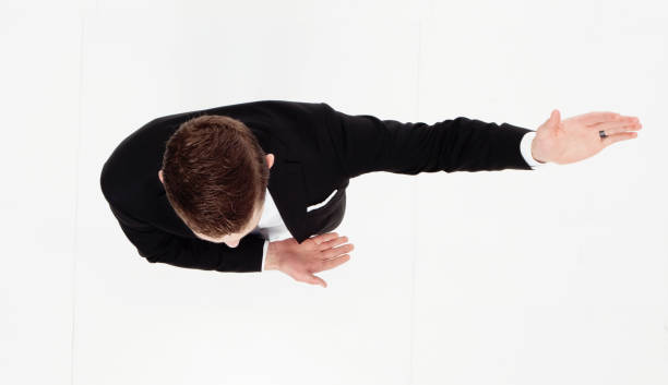 Full length / one man only / directly above view of 20-29 years old adult handsome people / tall person brown hair / short hair caucasian male / young men business person / businessman / presenter standing in front of white background in the office wearing businesswear / a suit who is showing / pointing / presenting longitud completa / un hombre solamente / directamente por encima de la vista de 20-29 años adulto sorguapo personas / alta persona cabello castaño / pelo corto hombre caucásico / hombres jóvenes hombre de negocios / hombre de negocios / presentador de