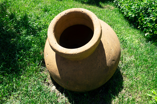 Ancient greek jug on green grass, garden furniture
