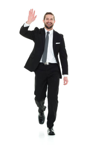 Full length / one man only / front view / looking at camera of 20-29 years old adult handsome people / tall person brown hair / short hair caucasian male / young men business person / businessman / manager walking in front of white background - fotografia de stock