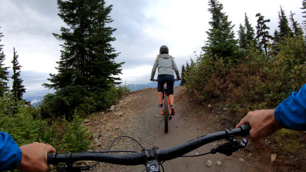 istock Mountain bikers descend through forest on muddy trail 1173966443