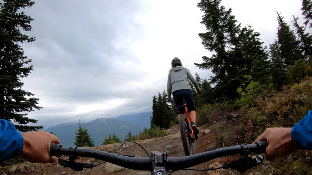 istock Mountain bikers descend through forest on muddy trail 1173966473