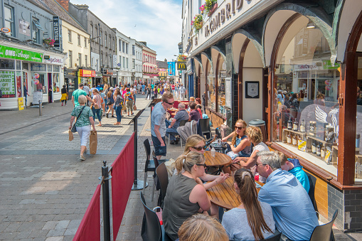 People relax on the patio of a cafe-restaurant in downtown Galway Ireland during lunch hour.