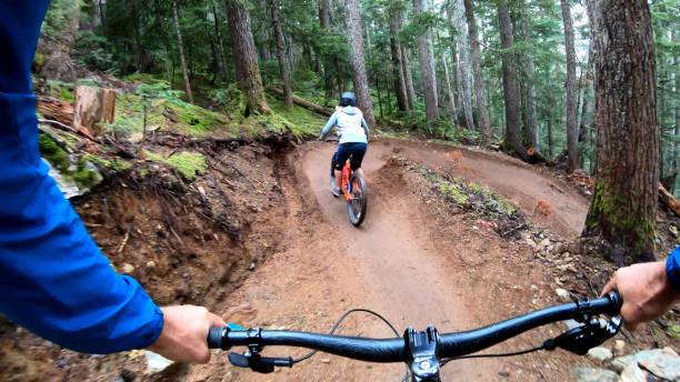 istock Mountain bikers descend through forest on muddy trail 1173966658
