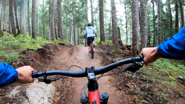 istock Mountain bikers descend through forest on muddy trail 1173966681