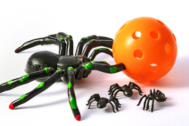 red and black spider doll, spider toy on white background free copyspace for text