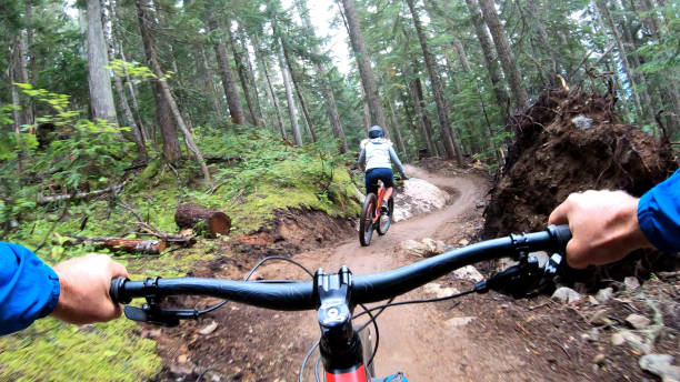 istock Mountain bikers descend through forest on muddy trail 1173966733