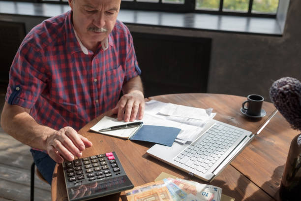 istock Senior hispanic man busy doing calculation, counting money and bills at home. 1173966849