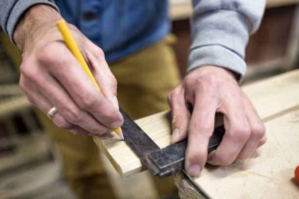 istock Carpenter using a straightedge to draw a line on a board 1173971997