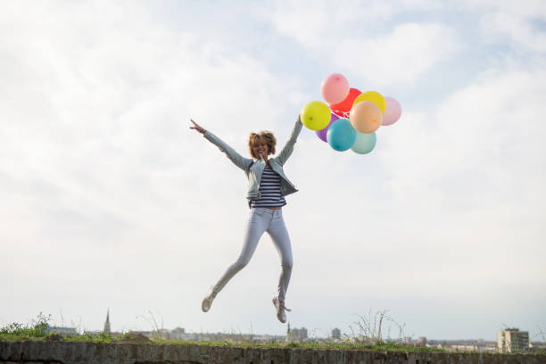 istock Happy young woman with balloons 1173987503