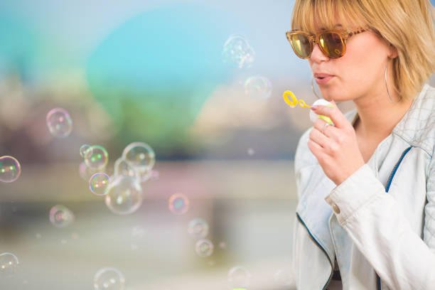 istock Beautiful young woman making soap balloons 1173988298