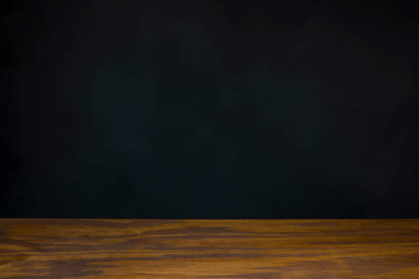 istock blank black chalkboard behind wooden desk 1174003576